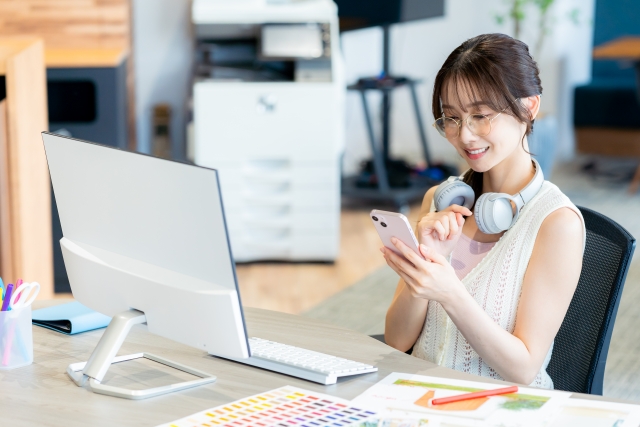 職場でスマホを見る女性